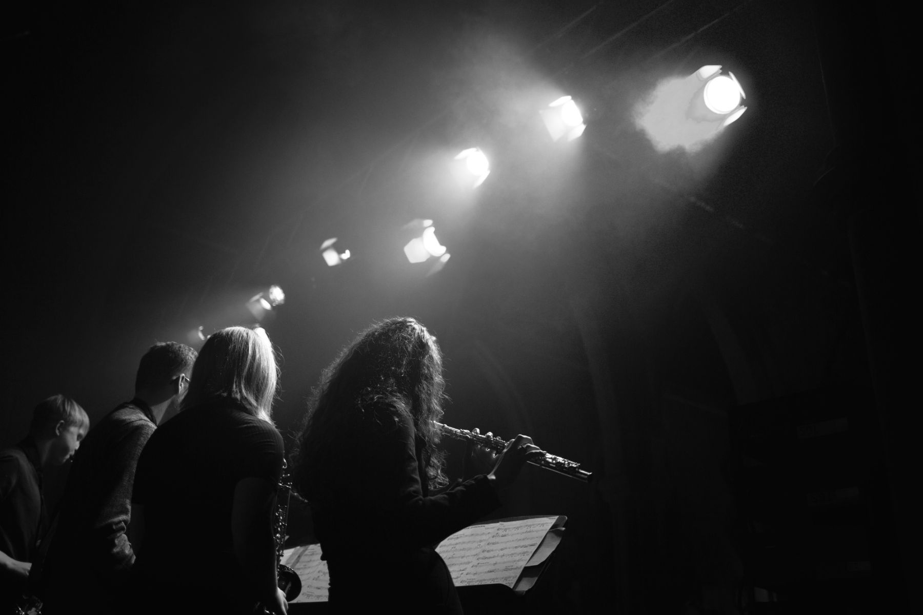 Black and white image of students performing music on a stage